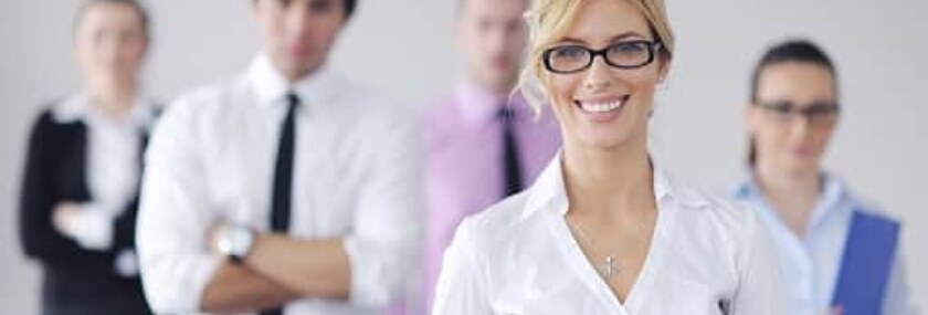 Business woman standing with her staff in background